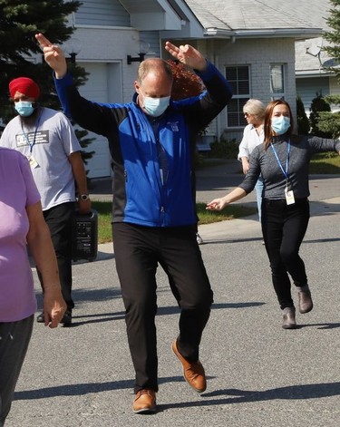 David Munch, CEO of Finlandia Village, struts his stuff as Finlandia Village townhouse residents and staff dance up and down a street at Finlandia in Sudbury, Ont. on Tuesday September 22, 2020. Fitness centre staff organized the event to provide residents with exercise and a social connection during the COVID-19 pandemic. John Lappa/Sudbury Star/Postmedia Network