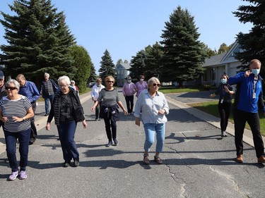 Finlandia Village townhouse residents and staff dance up and down a street at Finlandia in Sudbury, Ont. on Tuesday September 22, 2020. Fitness centre staff organized the event to provide residents with exercise and a social connection during the COVID-19 pandemic. John Lappa/Sudbury Star/Postmedia Network