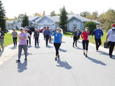 Finlandia Village townhouse residents and staff dance up and down a street at Finlandia in Sudbury, Ont. on Tuesday September 22, 2020. Fitness centre staff organized the event to provide residents with exercise and a social connection during the COVID-19 pandemic. John Lappa/Sudbury Star/Postmedia Network