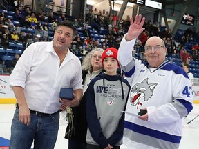Longtime Sudbury Wolves statistician Dave Harrison, right, waves to the crowd while standing alongside members of his family and Wolves owner Dario Zulich during a pre-game ceremony at Sudbury Community Arena on Saturday, March 2, 2019. GINO DONATO/XCALIBER TROPHIES