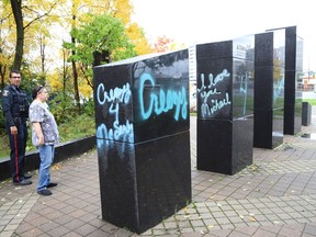 Linda Russell, of the Ukrainian Seniors' Centre, shows a Greater Sudbury Police officer graffiti sprayed on black granite sculptures located at Hnatyshyn Park near Lloyd Street hill and Notre Dame Avenue in Sudbury, Ont. on Monday September 28, 2020.