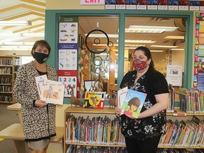 Christina Blazecka, CEO of the Library and Ardis Chedore, Assistant to the CEO hold a few of the books that are available to celebrate  First Nations Public Library Week.TP.JPG