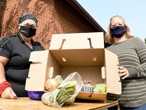 Dava Robichaud (left), events co-ordinator with TekSavvy, and Lyndsay Davidson, registered dietician with CK Public Health, display one of the boxes of fresh produce given away as part of the Mobile Miracle Market at Wheatley Baptist Church on Sept. 15.