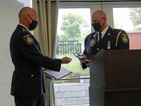 Woodstock police Chief Daryl Longworth, left, presents Deputy Chief Rod Wilkinson with his deputy chief badge during his swearing in ceremony in Woodstock, Ont. on Monday September 28, 2020. (Greg Colgan/Woodstock Sentinel-Review)