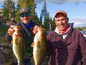 Ben and Jim Gustafson hold up a pair of largemouth bass that they caught on Sunday in the Bassin' For Bucks tournament.  These fish were part of a 22.15 pound limit the duo caught.