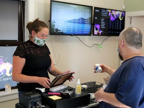Capturing Eden "budtender" Courtney Hawksworth helps a customer as Owen Sound's first legal retail marijuana shop celebrates opening day Saturday, Sept. 5. Greg Cowan/The Sun Times