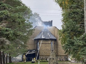 Firefighters hose down hot spots at the Wesley United Church building during a fire Sept. 28.
(David Shearman photo)