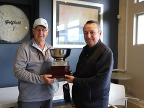 Ralph Courrier receives the men’s league trophy from Steve Williams, co-owner of the Greens at Renton. (CONTRIBUTED)