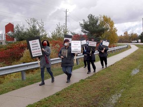A group marches toward the North Bay Regional Health Centre, Wednesday morning, to call for greater access for caregivers, in keeping with hospital policy. Michael Lee/The Nugget