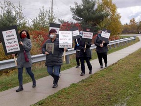 A group marches toward the North Bay Regional Health Centre, Wednesday morning, to call for greater access for caregivers, in keeping with hospital policy. Michael Lee/The Nugget