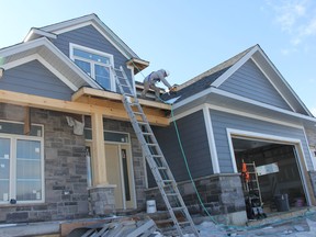 Jacob Dyck of Dyck Exterior Installation works on the roof of a house being built in Mt. Brydges, in this file photograph from early 2019. Jonathan Juha/Postmedia Network