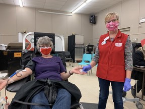 Angela Huey (left) receives a pin from Patty Henderson during her 100th time donating blood. Jake Romphf