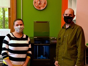 Stephanie Park, the Stratford Public Library's MakerSpace and marketing librarian, and MakerSpace assistant Eric Ball with a 3D printer. Photo taken in Stratford Ont. Oct. 14, 2020. GALEN SIMMONS/STRATFORD BEACON HERALD/POSTMEDIA NEWS