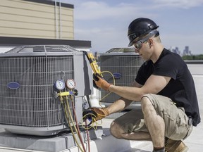 Hvac technician inspecting an condensing unit.