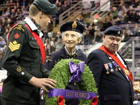 Representing Silver Cross Mothers, the Royal Canadian Legion's Frieda Wood walks up to lay a wreath, with Royal Canadian Army Cadet Sgt. Bradley Iob (left) and the Legion's Ken Buckle, during Remembrance Day ceremonies at Revolution Place on Saturday November 11, 2017 in Grande Prairie, Alta.