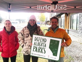 SkiUphill - RunUphill in Canmore hosted at Defend Alberta Parks lawn sign pick up day on October 12. (Pictured left to right) Volunteers from CPAWS in Canmore Katrina Solomenska, Naia Noyes-West, and Canmore resident Adam Campbell purchases his lawn sign. Photo submitted.