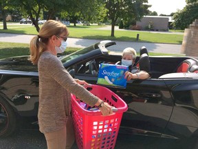 Marge Muharrem (left), of Women United, and Linda Reaume, president of the Chatham-Kent Labour Council, demonstrate how the drive-thru donation will work for Tampon Tuesday. Handout