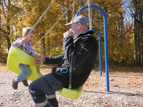 Corbin Johnson enjoys a ride with his dad, Matt Johnson, on a generation swing at the Trottier park on Baldwin Street, Tillsonburg. (Chris Abbott/Norfolk Tillsonburg News)