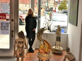 As part of the Outside/In public-art exhibition curated by Agora Gallery for Culture Days over the last month and a half, artist Tom Campbell’s sculptures have been on display in the front windows of six downtown businesses. Pictured, gallery owner and curator Cindy Hubert poses with Campbell’s campfire sculptures currently on display in the gallery’s front window. (Galen Simmons/The Beacon Herald)