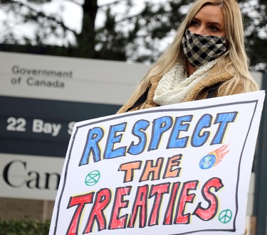 Demonstrators rally in support of Mi'kmaq fishermen in downtown Sault Ste. Marie, Ont., on Wednesday, Oct. 21, 2020. Sandra Holmberg holds sign outside federal government office building.  (BRIAN KELLY/THE SAULT STAR/POSTMEDIA NETWORK)