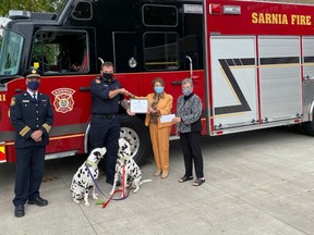 Sarnia firefighter Trevor Mitchell, and his Dalmatians Lucky and Clover, recently received a community relations award from the IODE in Sarnia-Lambton. From left, Fire Chief Bryan Van Gaver, Mitchell and the IODE's Leila Boushy and Helen Danby.