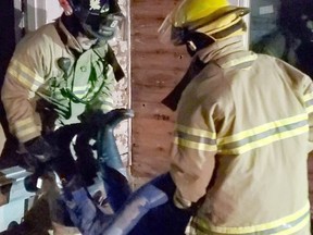 Lt. Darcy Robinson (left) and recruit Matt Smale remove a rescue mannequin while conducting a search and rescue exercise in a vacant home on James Street South. Contributed