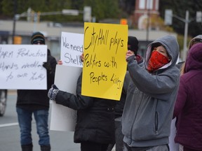 Corey Faries protests outside Tom Davies Square on Sunday along with other members of No More, a group calling for action on opioids, and the Freedom Keepers, who oppose mandatory vaccinations and mask wearing.