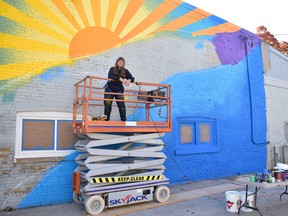 Tova Hasiwar takes a break from painting her mural on the side of Seaforth Plumbing and Heating. The mural is expected to be unveiled to the public soon as the final art installation this year for the exhibit “Art That’s Right Up Your Alley.” Daniel Caudle