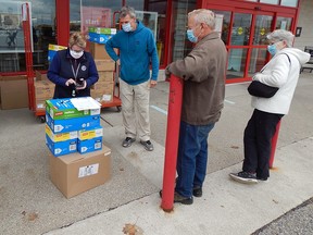 Local Start to Smart co-organizer Sheila Donald (left) hands out boxes of supplies to Kiwanis volunteers to deliver to local elementary schools. Carl Hnatyshyn/Sarnia This Week