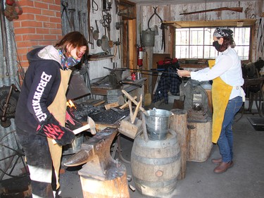 Petawawa Heritage Village volunteers Cat Harrison, left, and Julie Hollinger were hard at work in the blacksmith's shop on Saturday, Oct. 17. Anthony Dixon