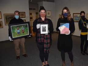 Staff of the Tom Thomson Art Gallery hold pieces that are part of the Grouping of Seven online fundraising auction that will run from Nov. 7 to 20. The auction includes two works by each of seven talented local artists in a variety of mediums. From left are Curator of Collections David Huff holding Willy Waterton's photograph on watercolour paper Covid Gothic (2020), Visitor Services and Membership Coordinator Hillary Weppler holding Tony Miller's limited edition print The Arrival (2018), Exhibitions Assistant Shannon Bingeman holding Kristine Moran's oil on linen Sacred Heart (2020), and Director and Chief Curator Aidan Ware holding Emily Kewageshig's acrylic on canvas Resting in Time (2020).