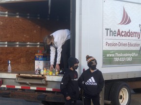 Students at the Academy load non-perishable food items into the back of the Academy cube van during the Dare to Scare food drive, held at the Coca-Cola Centre on Wednesday night.