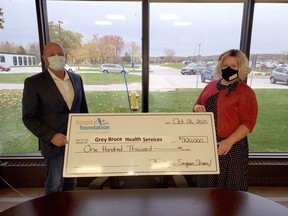 Grey Bruce Health Services president and CEO Gary Sims receives a $100,000 cheque from Saugeen Memorial Hospital Foundation executive director Tracy Murray. The money finishes a commitment to pay toward four new defibrillators for the hospital in Southampton.