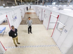 Derek Lall of London Health Science Centre and Dr. Ian Ball, a critical care doctor, stand in the field hospital at the Western Fair's Agriplex in London. The 144-bed facility is designed to treat patients who are on the mend from COVID-19 but not yet well enough to go home. Mike Hensen/Postmedia Network