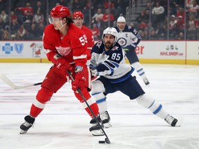 Tyler Bertuzzi (59) of the Detroit Red Wings looks to pass the puck in front of Mathieu Perreault (85) of the Winnipeg Jets during the first period at Little Caesars Arena on December 12, 2019 in Detroit.