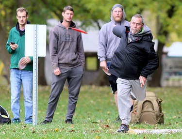 Bill Johnston throws during a game with Ricky Friesen, left, DJ Neufeld and Brandon Rice at the Thames Grove Disc Golf Course at the Thames Grove Conservation Area in Chatham, Ont., on Saturday, Oct. 24, 2020. Mark Malone/Chatham Daily News/Postmedia Network