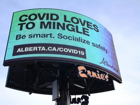 A digital billboard displays a message from the Government of Alberta advising people to socialize safety during the COVID-19 pandemic in front of Ernie's Sports Experts at the intersection of 100 Street and 115 Avenue in Grande Prairie, Alta. on Wednesday, Oct. 7, 2020.