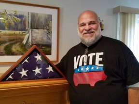 American-born Dave Carr with his military father's memorial flag. The longtime, retired local radio host cast a vote in ahead of the Nov. 3 U.S. election to make America "nice" again. (Scott Dunn/The Sun Times/Postmedia Network)