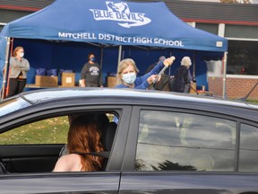 MDHS Principal Petra Goetz uses a hockey stick to deliver graduation packages to students during the school's "drive through" event Oct. 23 at the school. ANDY BADER/MITCHELL ADVOCATE