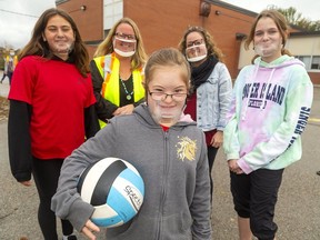 Keira Beattie is surrounded by smiling faces at St. George Catholic elementary school. Classmate Sophie Morgan, educational assistant Kelly Gagen, teacher Vanessa Vecchio and classmate Sydney Orange wear clear masks that allow Keira, who is deaf, to read lips. (Mike Hensen/The London Free Press)
