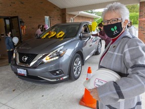 Plains Baptist Church near Sparta celebrated its 190th year on Sunday with a drive-through celebration. 
Pastor Margaret Bell, holding a site supervisor hardhat, was on hand to say hello to the congregation.
(Mike Hensen/Postmedia Network)