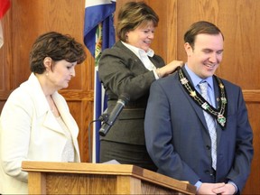 Coun. Tammy Hart places the chain of office on newly elected Warden Eric Duncan in December 2014 in the United Counties of SDG council chambers. This was the second consecutive year for Duncan as warden.