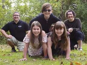 Eli Stuart balances on the backs of his fellow triplets, Leah, left, and Marley while at their Thurlow home with parents Dez and Jess. The "10-10-10" triplets, born Oct. 10, 2010, are now turning 10.