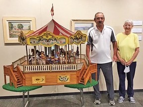 Mike and Barb Lamoureux are shown with their colourful replica carousel model which they recently donated to the John M. Parrott Gallery in Belleville Public Library. SUBMITTED PHOTO