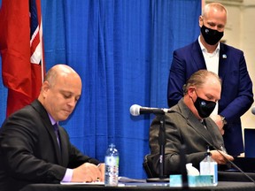 Mayor Mitch Panciuk, left, and Jamie Chatten, president of the Belleville Agricultural Society, signed a new memorandum of understanding Thursday as city clerk Matt Macdonald [standing) looks on to relocate the society and city fairgrounds to a new property in Thurlow. DEREK BALDWIN