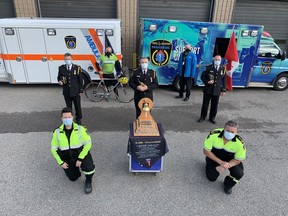 Members of the Brant/Brantford Paramedic Services surround the Paramedic Bell at the Henry Street station on Monday to pay tribute to paramedics who lost their lives in the line of duty. In the photo are: Sarah Leslie (front, left). Mike Polgar, Deputy Chief Kevin Robinson (middle left), Chief Russ King, Deputy Chief Neil Vanderpost, retired paramedic Randy Papple (back, left) and Milan Novakovic, representing Brantford-Brant MPP Will Bouma.