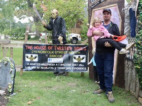 Derek King and four-year-old daughter, Santana, show off decorations outside of their Simcoe home for Halloween. The Kings turn their home into The House of Twisted Souls each October to raise money and collect food items for local food banks. ASHLEY TAYLOR