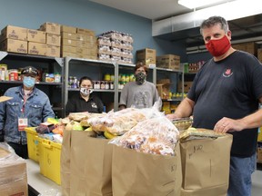 Volunteer Bill Lise (left), community family services worker Nicole Bouw, volunteer Brendan Mitchell and Will Ratelband, family services co-ordinator, pack up some bags at the food bank operated by the Salvation Army on Diana Avenue. The Salvation Army will be operating its Community Christmas Hamper Program differently this year due to COVID-19 restrictions. MICHELLE RUBY PHOTO
