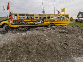 A wrecked school bus and dug-up asphalt form a barricade on Argyle Street South in Caledonia, near the McKenzie Meadows residential development, dubbed 1492 Landback Lane by protesters who have occupied the site since July 19. Brian Thompson/Brantford Expositor/Postmedia Network