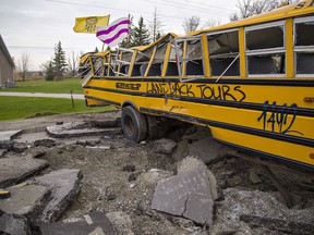 A wrecked school bus and dug-up asphalt form a barricade on Argyle Street South in Caledonia, near the McKenzie Meadows residential development, dubbed 1492 Landback Lane by protesters who have occupied the site since July 19. Brian Thompson/Brantford Expositor/Postmedia Network